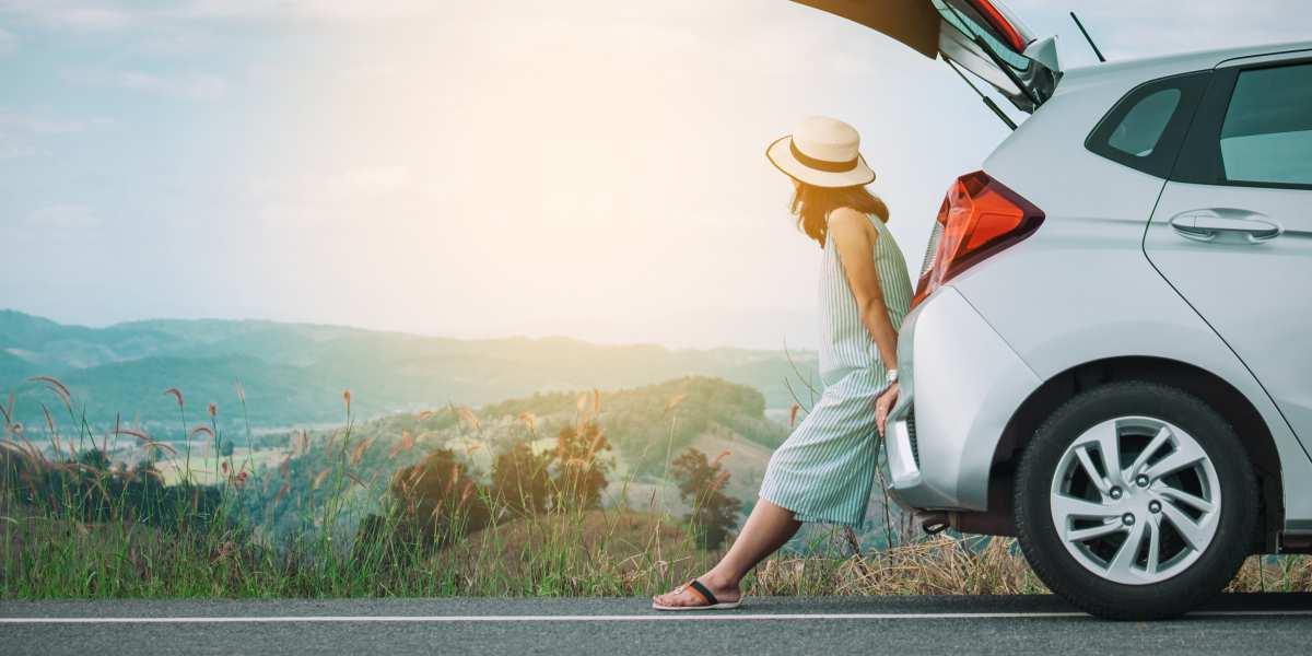 Woman leaning on car watching scenery